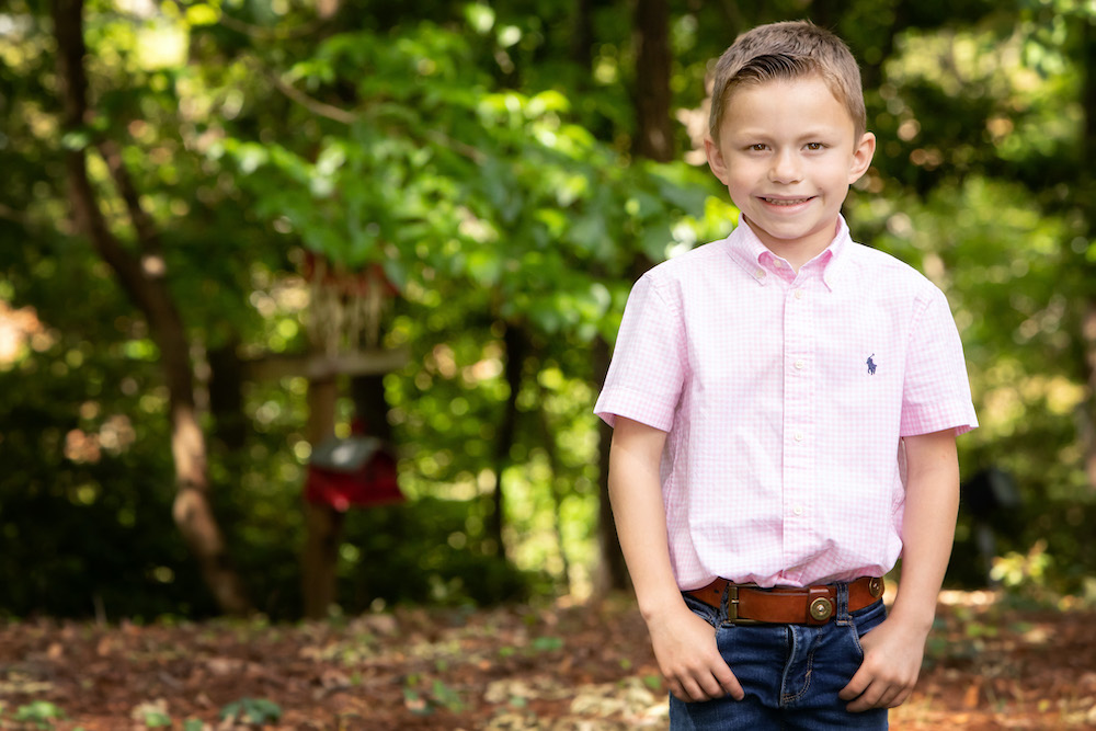 Young boy with pink shirt and pants while smiling