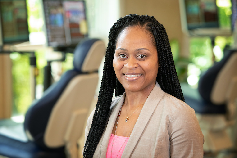 African American female smiling at the camera in a dental practice setting.