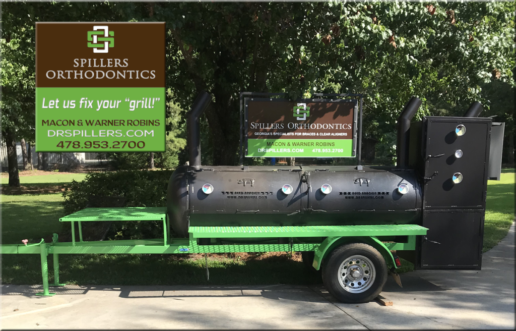 Photo of a grill holding the sign of "Spillers Orthodontics," and it's painted in black and green.